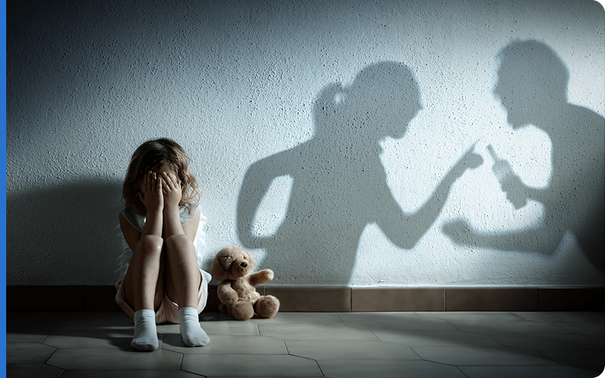 Dziewczynka płacząca w korytarzu podczas kłótni rodziców