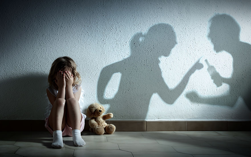Dziewczynka płacząca w korytarzu podczas kłótni rodziców